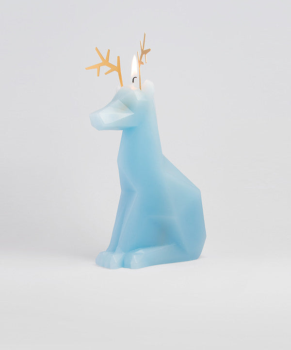 Side view of burning light blue dyri the reindeer animal shaped candle.